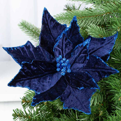 Artificial Velveteen Poinsettia in Navy with dark blue petals and blue glitter edges, attached to green pine branches. Available sizes: small, medium, large.