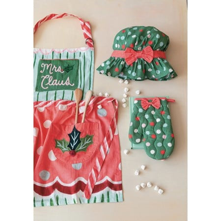 Mrs Claus child apron set with pattern, embroidery, and pom poms, including a matching chef hat, candy cane-striped oven mitt with holly, and two wooden spoons.