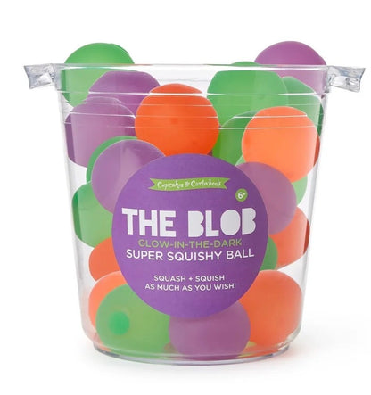 Green, orange, and purple Glow In The Dark Blob Squishy balls in a transparent bucket. For ages 6+. Glows in the dark. Available sizes: not specified.