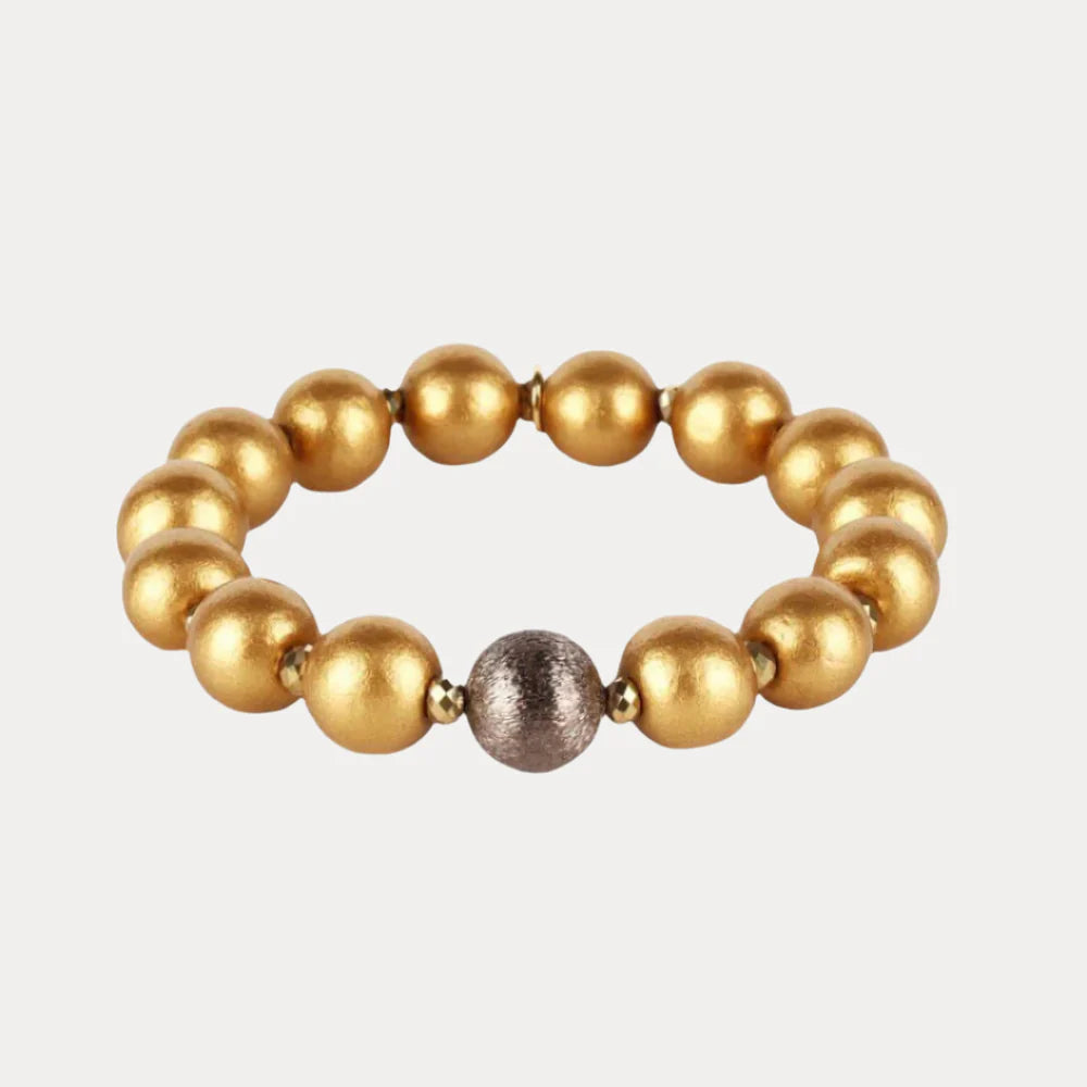 Shaanti Bracelet with eleven polished gold beads and one textured silver bead on a stretchy band; handcrafted in the USA; available sizes not specified.