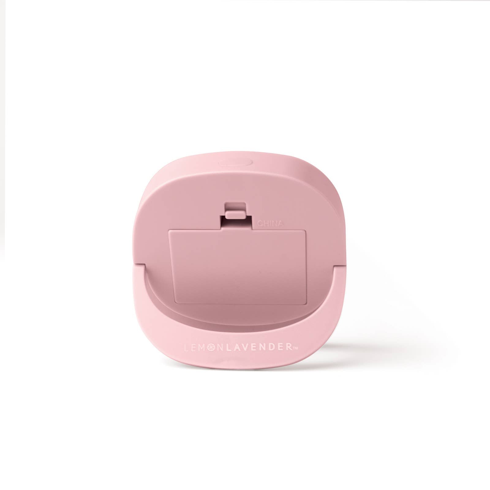 The product is a pink compact LED light-up mini mirror labeled "Lemon Lavender." This round makeup mirror comes with a clip on the back for easy attachment. The item is made from durable plastic and features a light proportion, making it travel-friendly. It has "China" inscribed on it denoting its origin.