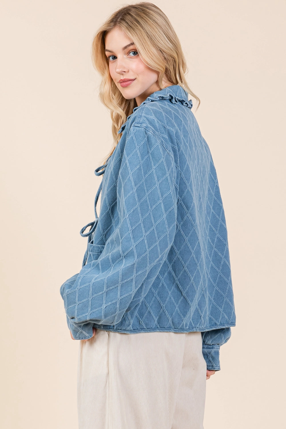 Quilted Denim Jacket: Blue color, quilted design, ruffle hem collar, tie details. Available sizes: XS, S, M, L, XL.