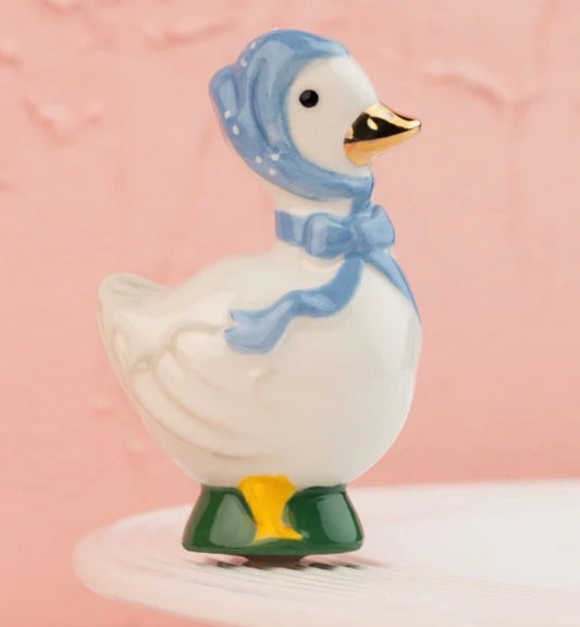 The 80s Goose Porch Pal is a ceramic figurine with a blue bonnet, ribbon, green shoes, and gold-tipped beak. Available sizes: small (6″), medium (10″), large (14″).