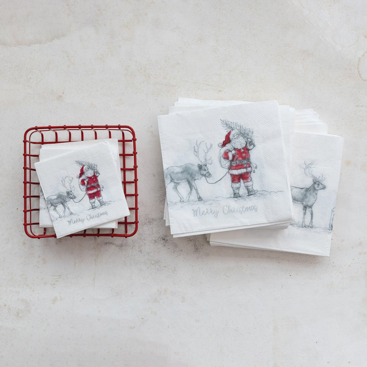 White paper napkins featuring a Santa and reindeer sketch with “Merry Christmas” text.