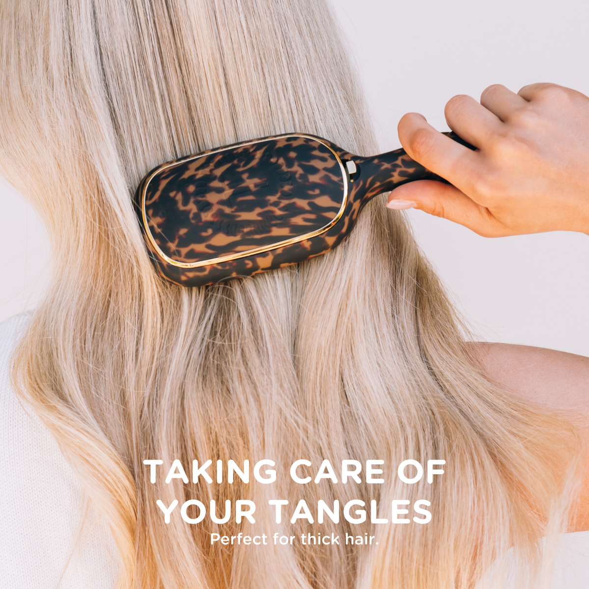 Detangler Hair Brush for Thick Hair - Tortoise shown in use. Available sizes: standard, large. Text at the bottom reads, “Taking care of your tangles. Perfect for thick hair.”.