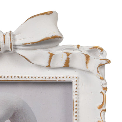 Plastic photo frame with ornate details, large top bow, gold accents; vintage style. Fits 4x6 photos.