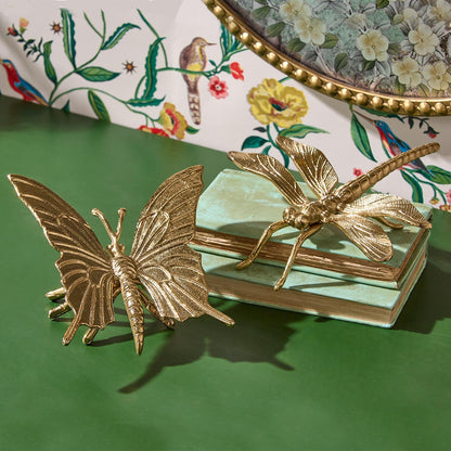 Gold butterfly and dragonfly aluminum figurines from the Flora and Fauna Nature Decor set, displayed on a green surface. Available in small (4″), medium (6″), and large (8″) sizes.