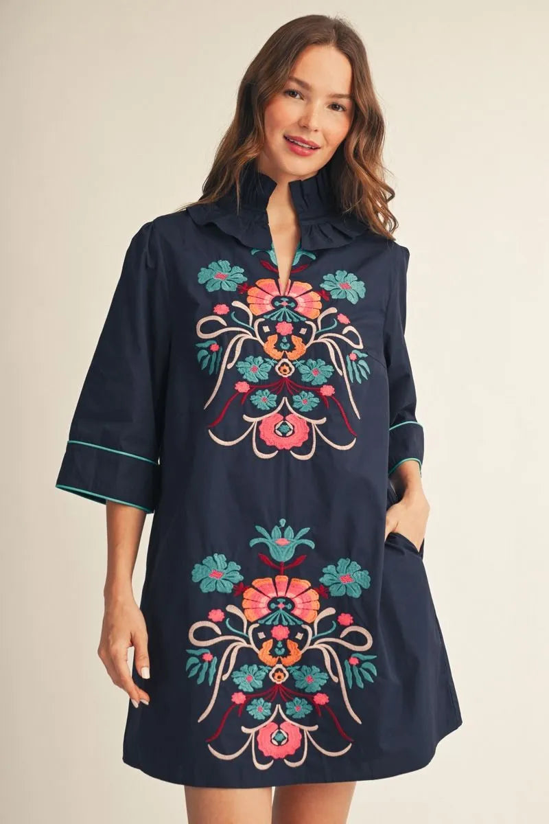 Cecilia Floral Embroidered Dress: navy mini dress with colorful front embroidery, three-quarter sleeves, and light trim. Available in sizes XS–XL.