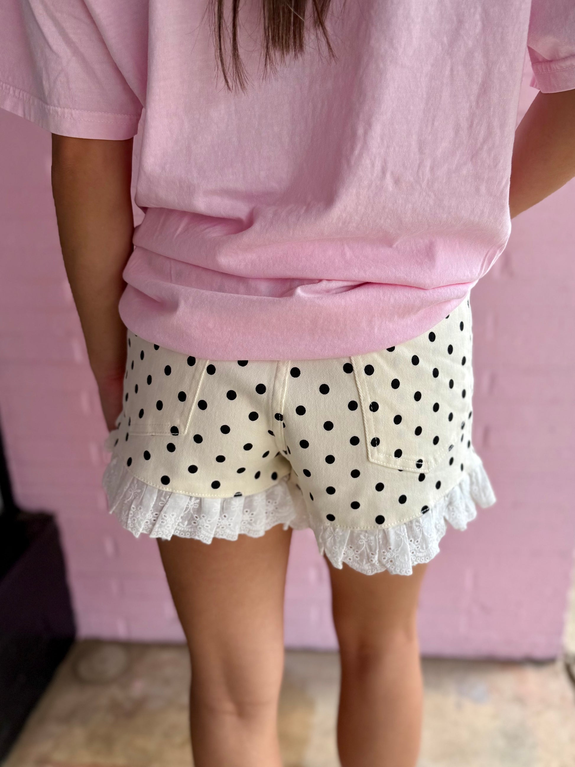 Dottie Denim Ruffle Shorts, available in sizes 2T-6T, feature ruffle trim and medium-wash denim.