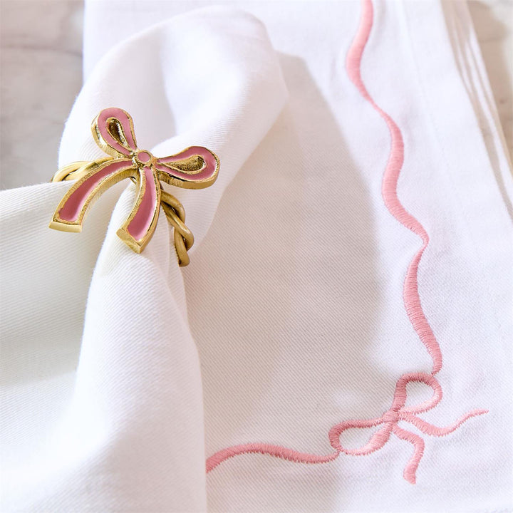 Set of 4 white cotton dinner napkins with pink edging and embroidered bows. Sizes available: 20"x20".