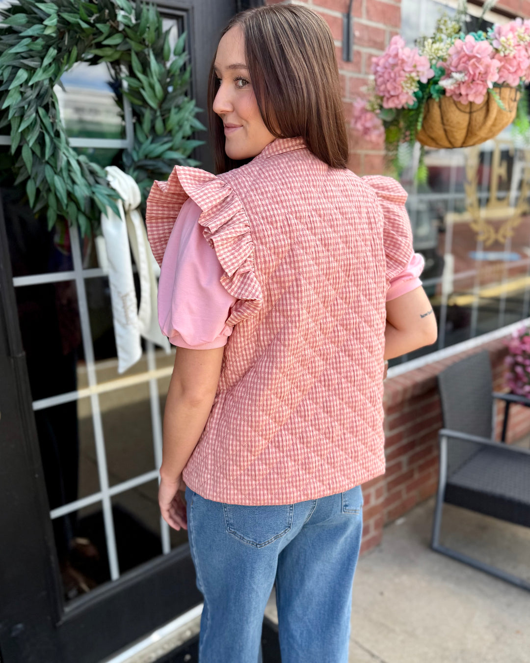 Blush Gingham Puffer Vest with ruffled sleeve collar. Available in sizes XS–XL.