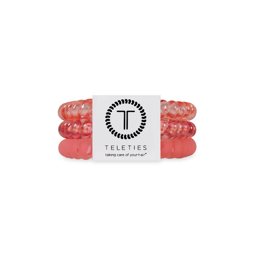 Three pink, coiled TELETIES Hair Ties stacked with a white branded label; available in small and large sizes.