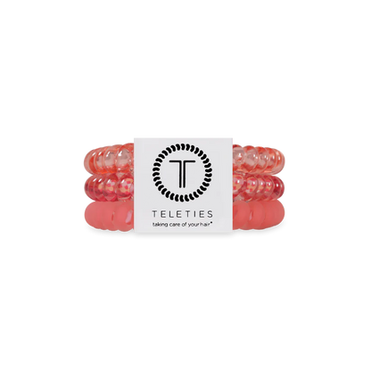 Three pink, coiled TELETIES Hair Ties stacked with a white branded label; available in small and large sizes.