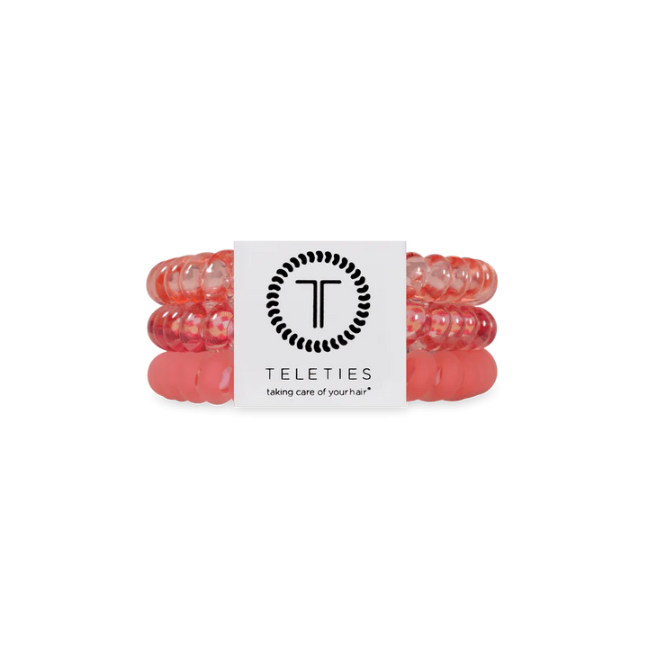 Three pink, coiled TELETIES Hair Ties stacked with a white branded label; available in small and large sizes.