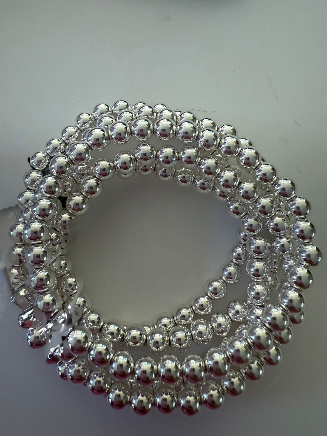 Beaded Stretch Bracelet with shiny silver beads in a coiled design. Available sizes: small, medium, large.