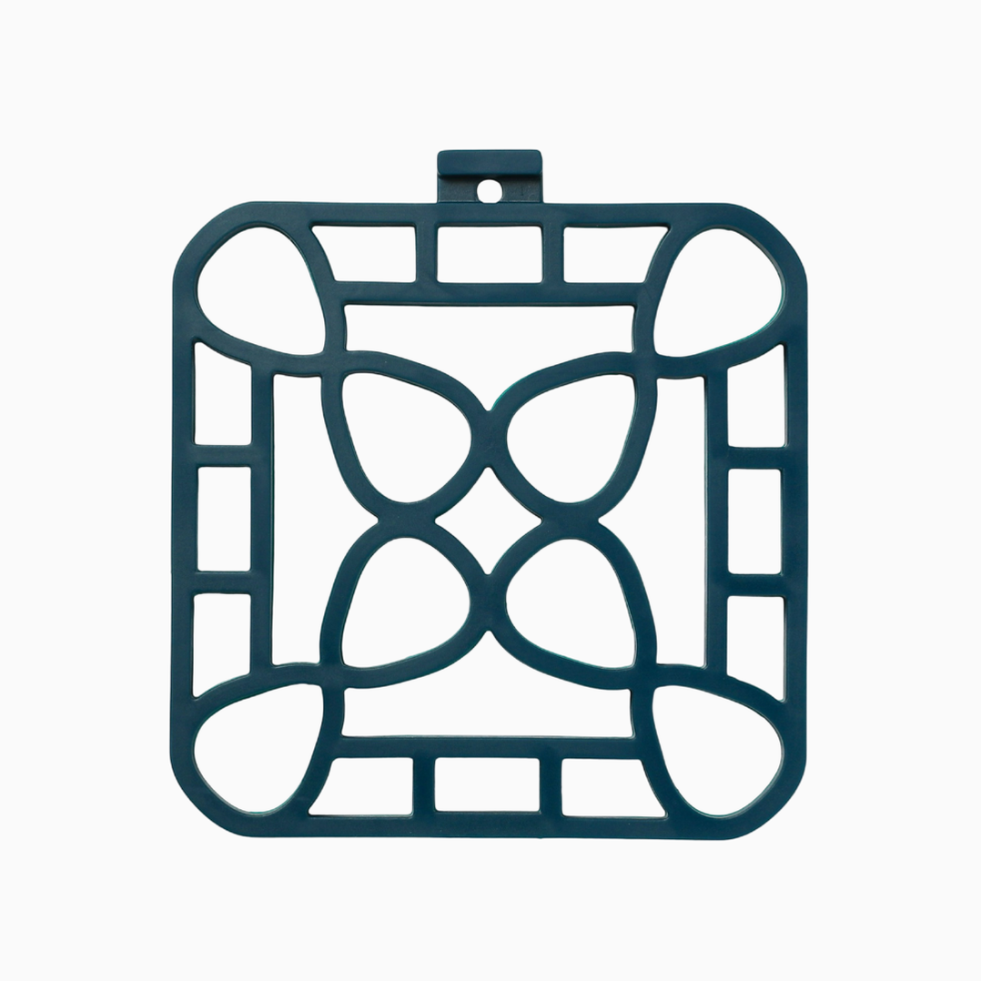 Dark green square trivet with geometric cutouts and a hanging loop. Heat-resistant. Available in 7" and 9" sizes.