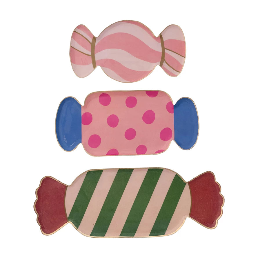 Three enameled metal candy-shaped trays: small pink-and-white striped, medium pink-and-blue polka-dot, and large green-striped with red ends.