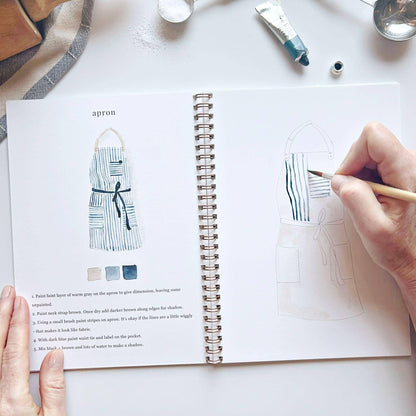 A hand sketches in the Baking watercolor workbook, which features step-by-step instructions and printed images. Available sizes: 8″x10″, 9″x12″.