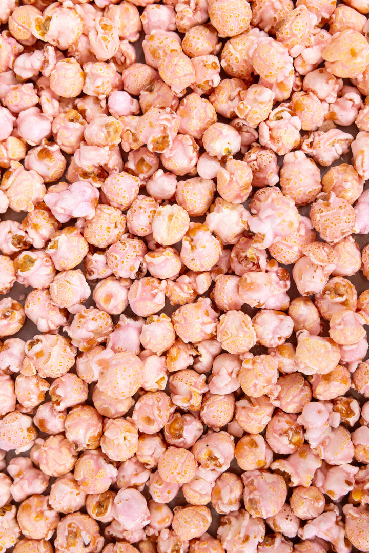 Glossy pink-coated Cotton Candy Popcorn, limited-edition, available in small and large sizes.