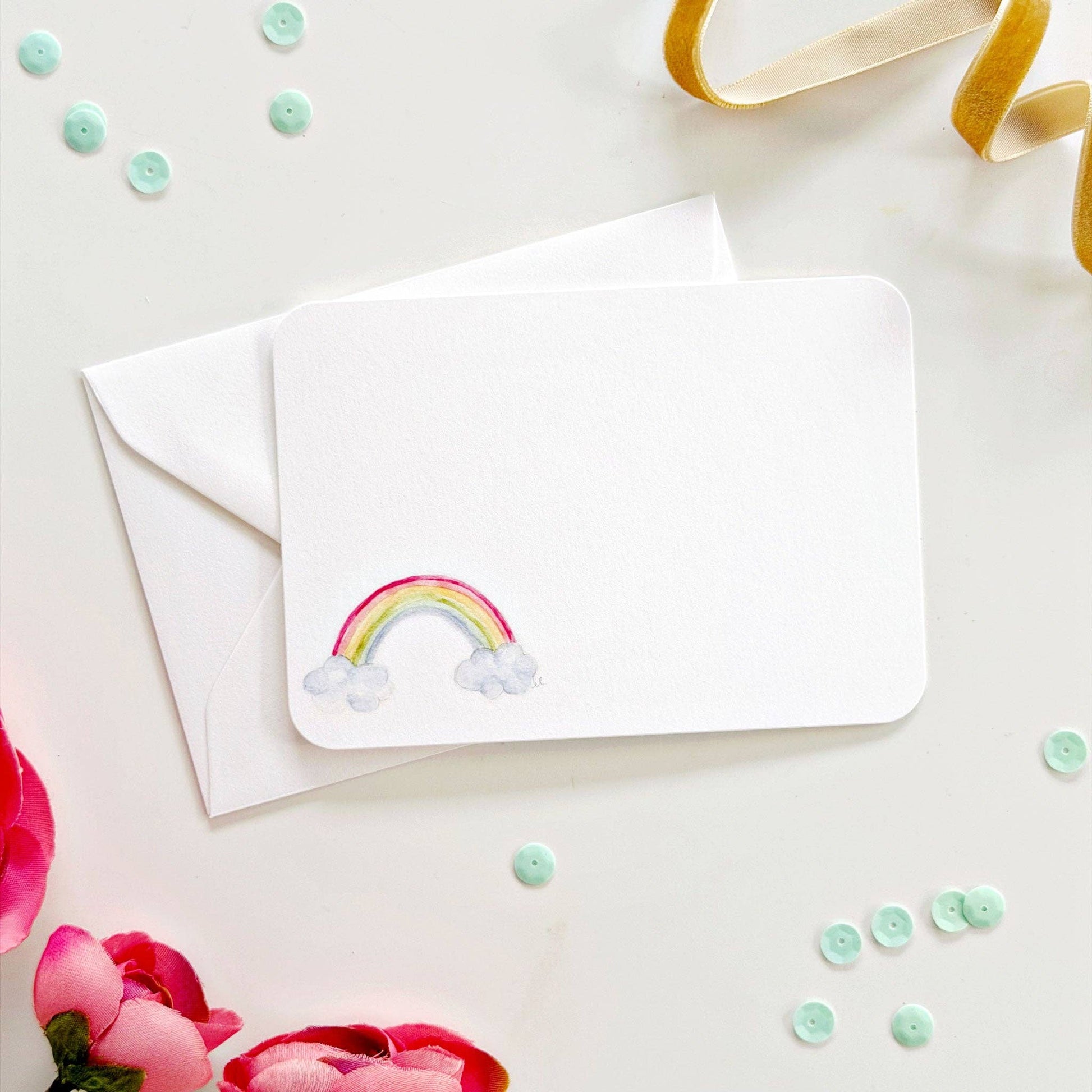 Blank white notecard with hand-painted rainbow and clouds in one corner; includes matching envelope. Sizes available.