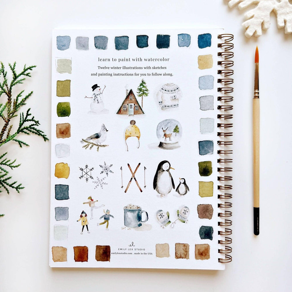 Spiral-bound winter watercolor workbook for beginners with instructional text, twelve winter illustrations, and color swatches.