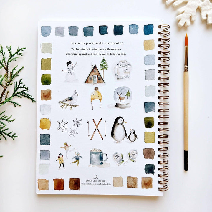 Spiral-bound winter watercolor workbook for beginners with instructional text, twelve winter illustrations, and color swatches.