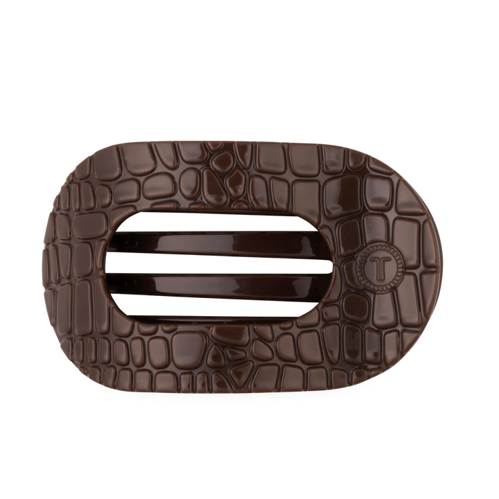 The Brown Crocodile Large Flat Round Hair Clip is a dark brown, oval accessory with a crocodile skin texture, two solid center bars, and a flat back for secure wear. Available in large size.