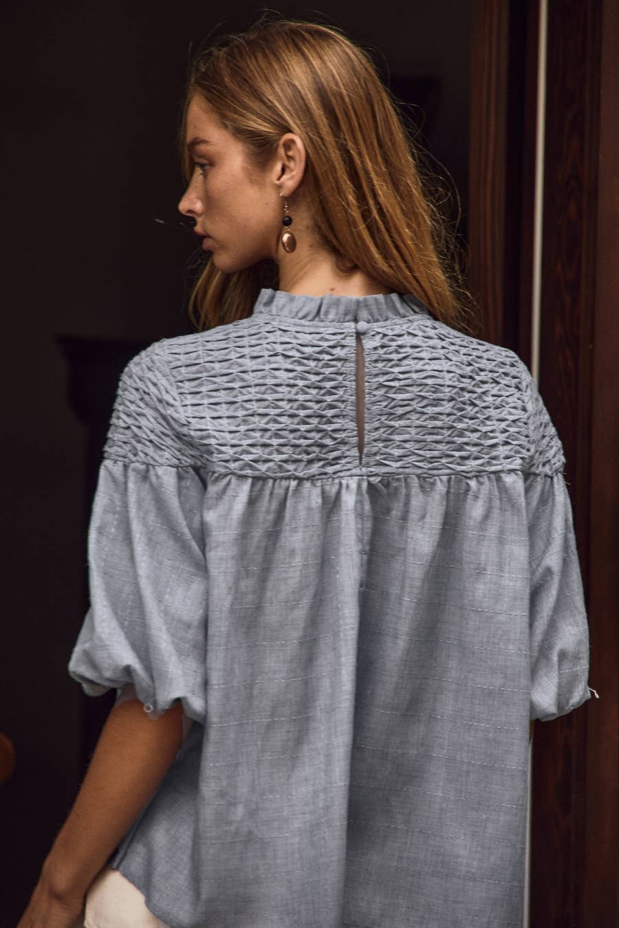Blue Bubble Sleeve Blouse in size S, featuring textured bubble short puff sleeves, subtle keyhole back detail, and a smocked mock neckline. Available in sizes S and up.