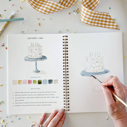 Celebrate watercolor workbook shown open in a sketchbook, used as a painting guide. Available sizes: standard and large.