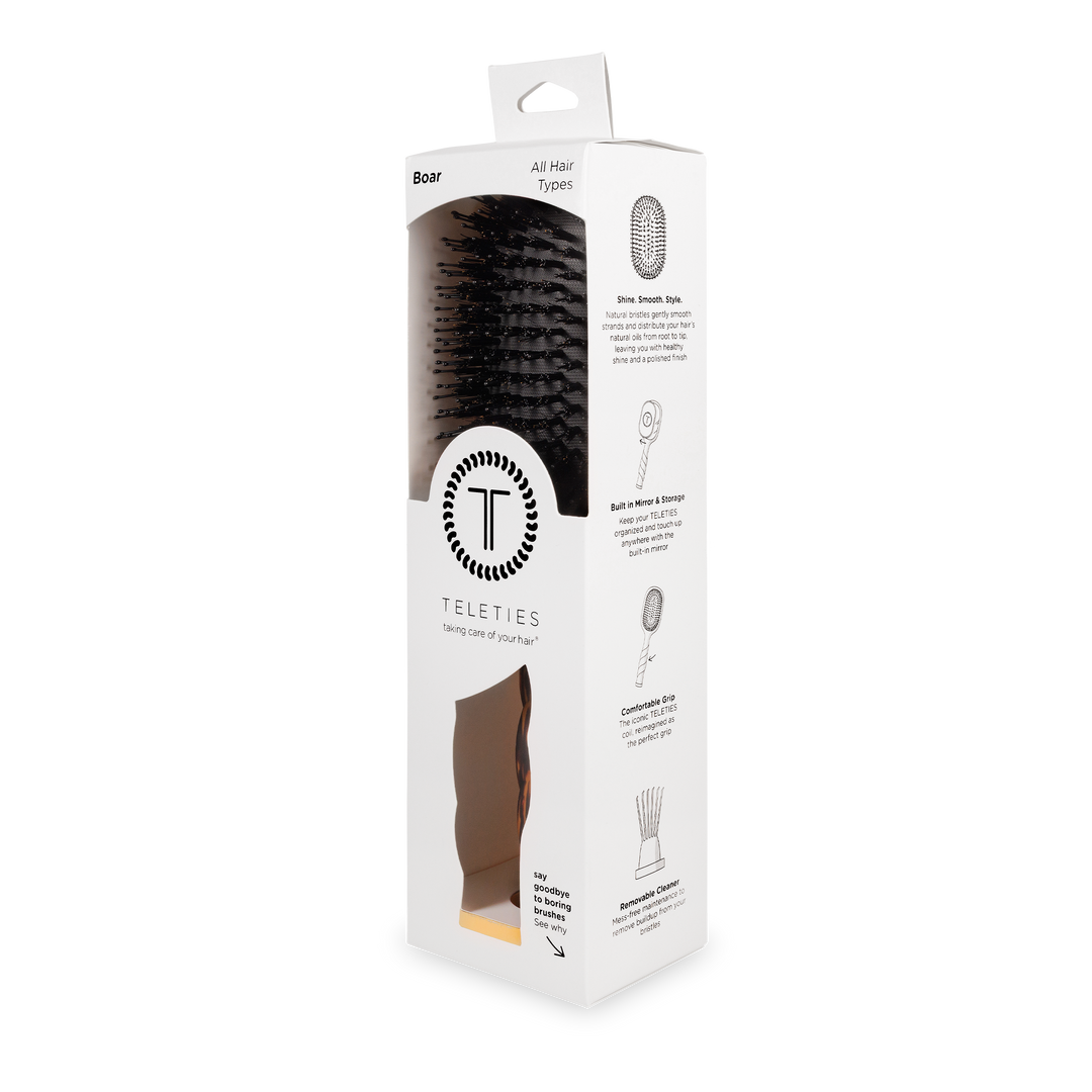 White box with clear window displaying black boar bristle hair brush; sizes available: small, medium, large.