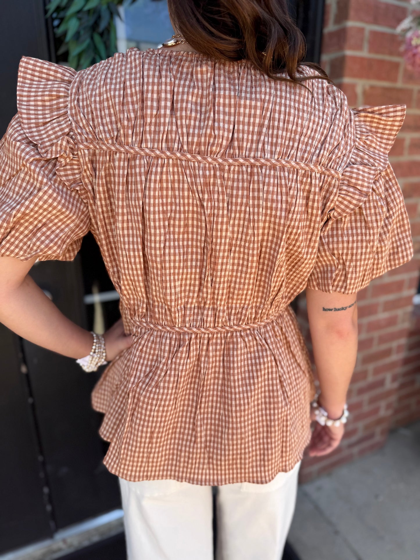 Gingham Tie Blouse in brown and white checks with ruffled flutter sleeves; available in sizes XS to XL.
