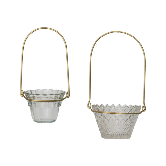 Two pressed glass votive holders with scalloped edges, textured patterns, and antique brass handles. Available in two sizes.