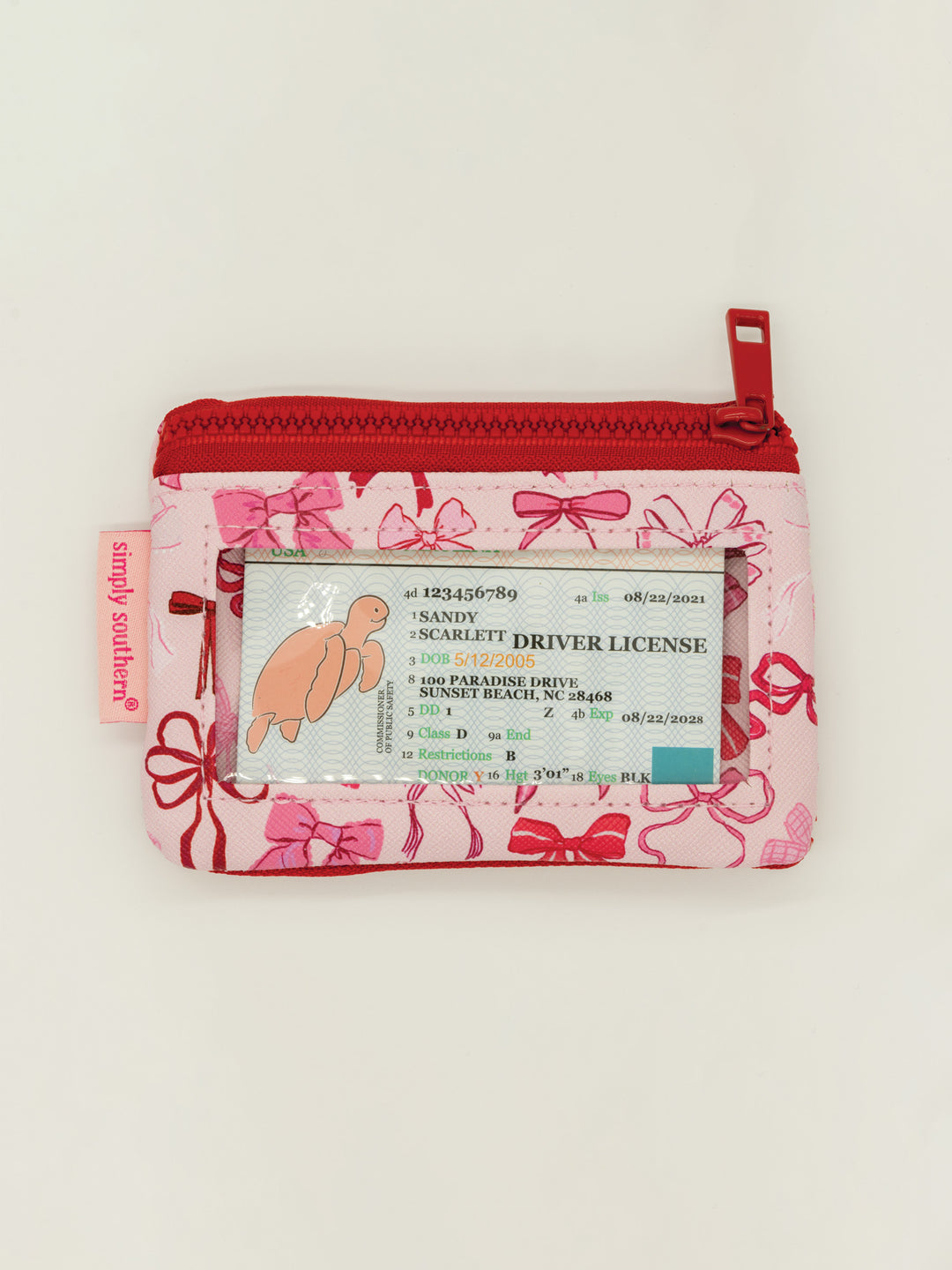 Pink Key Chain Wallet with red zipper, bow pattern, zip pockets, clear ID window. "Simply Southern" tag. Sizes: S, M, L.