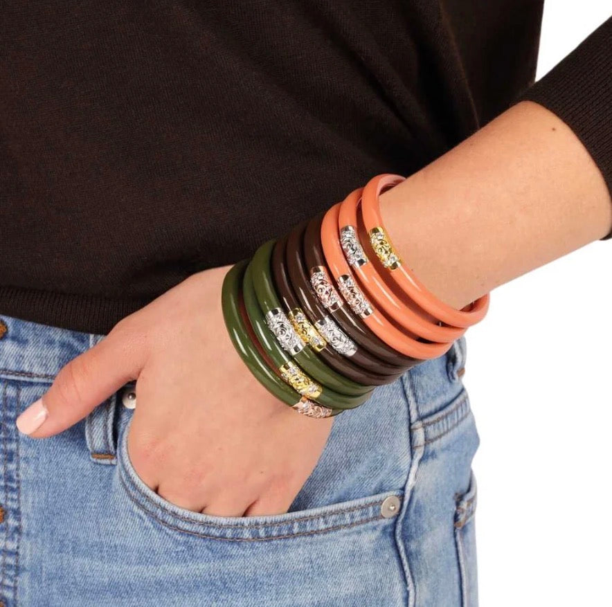 Set of eight green, brown, and orange Three Kings All Weather Bangles | Jade by BuDhaGirl, each with gold and silver snake head details. Available in sizes small, medium, large.