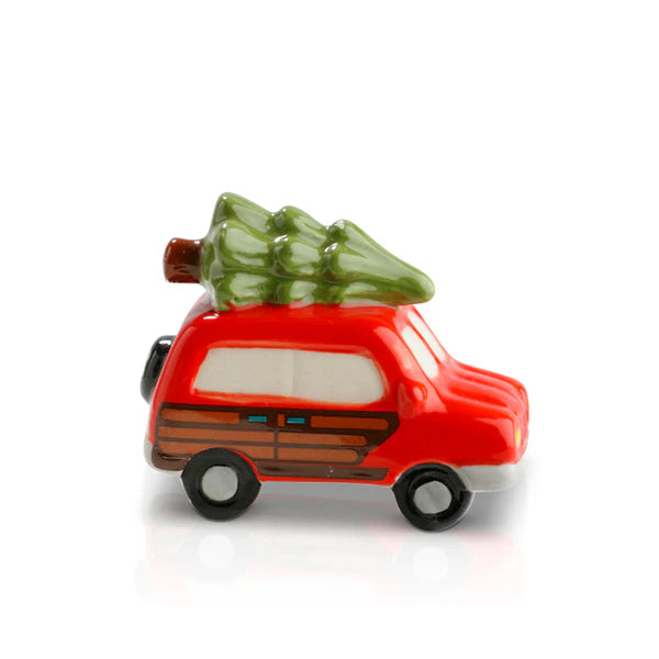 Nora Fleming Minis red car figurine with wood paneling and green tree on roof; available in standard mini size.