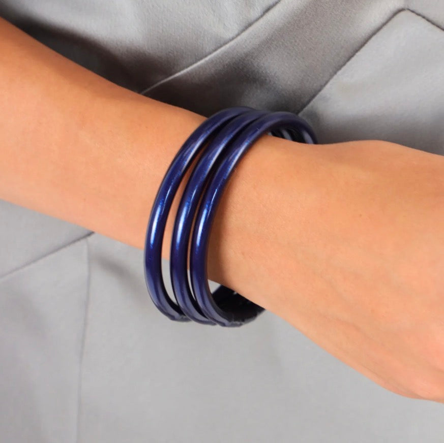 Three shiny, dark blue Midnight All Weather Bangles available in small, medium, and large.