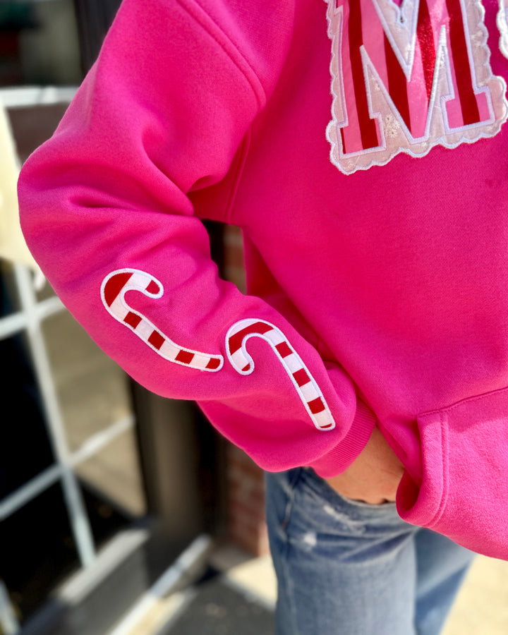 Striped Scallop Merry Hoodie with candy cane sleeve designs and a large “M” on the chest; available in sizes S-XXL.