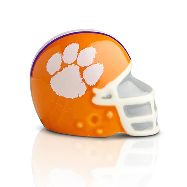 Orange football helmet mini with white paw print and faceguard, available in standard Nora Fleming Minis size.