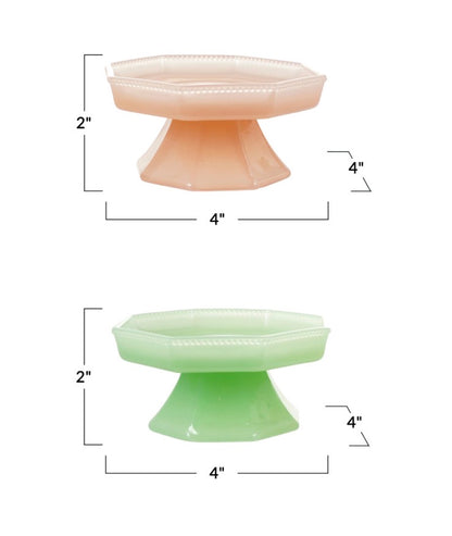 Pressed milk glass pedestals in pink and green, each 4 inches wide by 2 inches tall, with octagonal tops and flared bases.