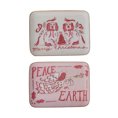Two enameled metal holiday trays: one with two dogs, a Christmas tree, and “Merry Christmas,” the other with an angel and “Peace on Earth.”.