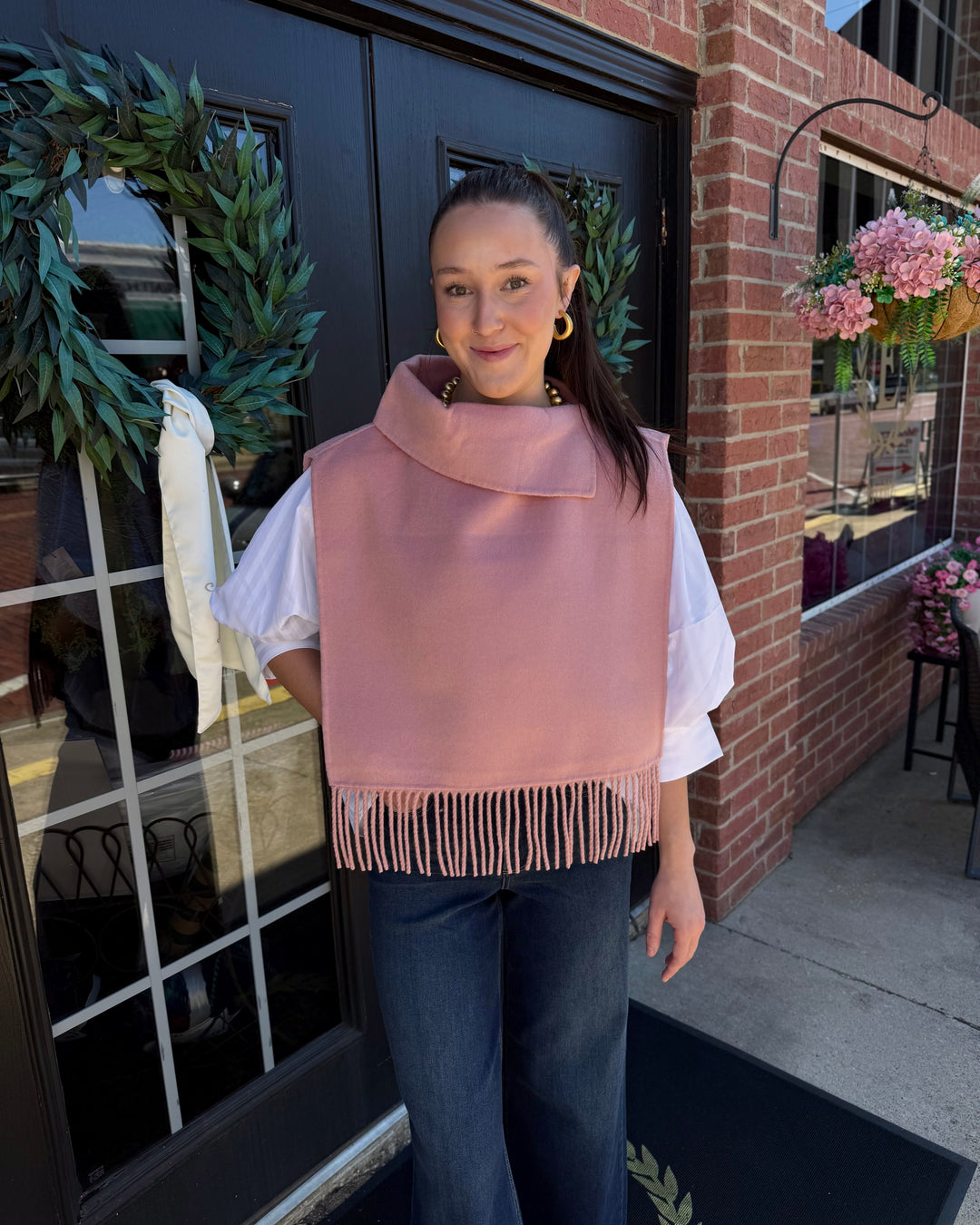 Blush pink cowl-neck poncho with fringe trim. Sizes available.