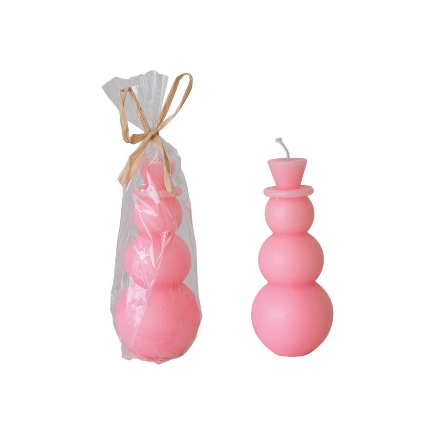 Two unscented pink snowman candles, one unwrapped and one wrapped.