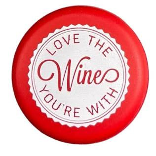 Red circular wine cap, white center with “Love the Wine You’re With” in red text. Available in standard wine bottle size.