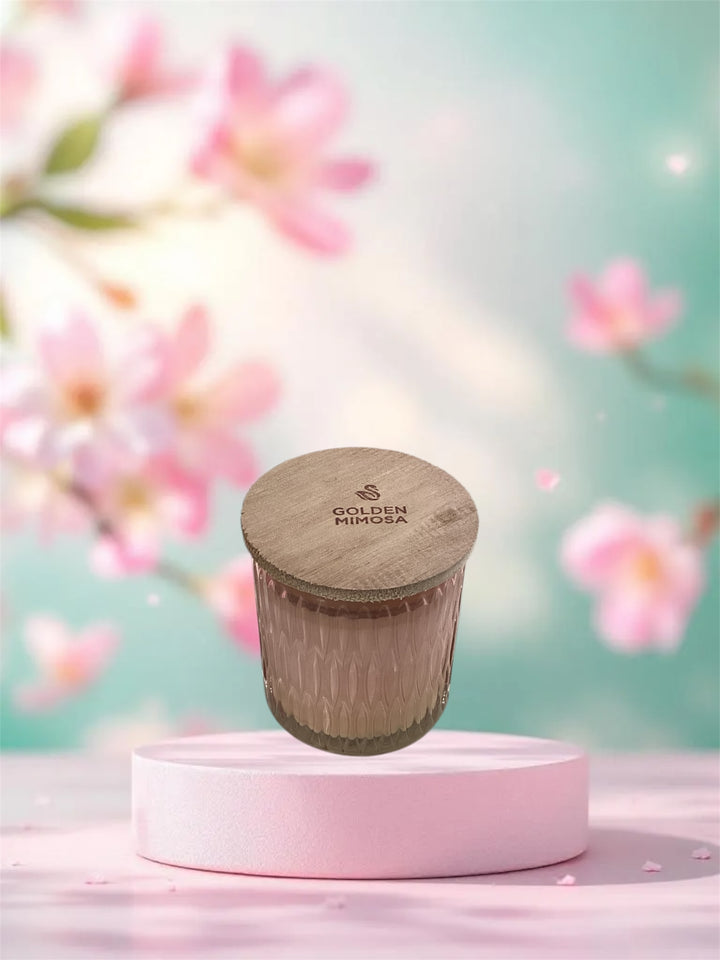 Golden Mimosa Cathedral Candle in a textured pink glass jar with a logo-branded wooden lid.