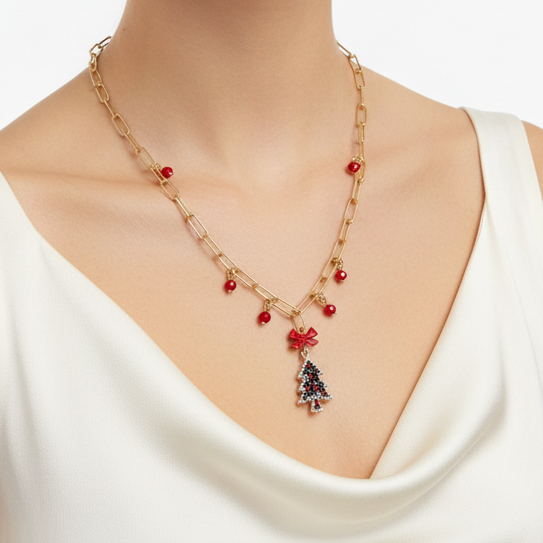 Gold chain necklace with red beads and a central Christmas tree charm with a red bow.