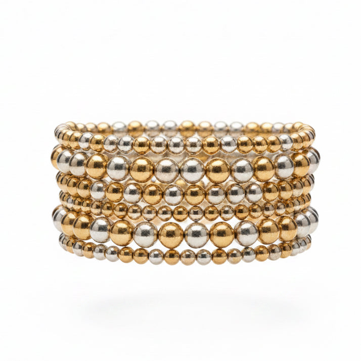 The Hunter 6-Strand Stretch Bracelet Stack features alternating gold and silver metallic beads in varying sizes, creating a wide stack. Available in one size fits most.