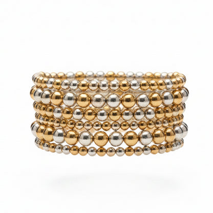 The Hunter 6-Strand Stretch Bracelet Stack features alternating gold and silver metallic beads in varying sizes, creating a wide stack. Available in one size fits most.