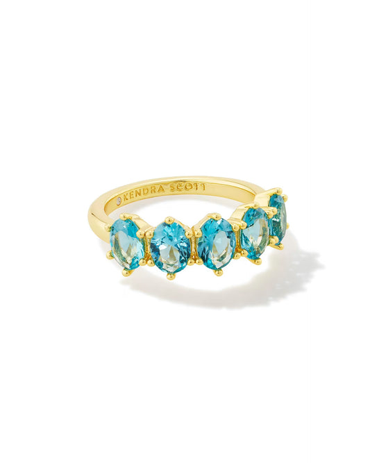 Gold band ring with five cobalt blue oval stones in a row, "Kendra Scott" engraved inside; available in sizes 5–9.
