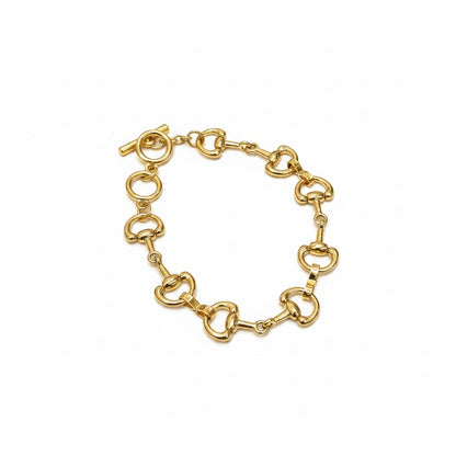 The Harry Gold Horse Bit Toggle Bracelet has alternating round and heart-shaped links, small connecting rings, and a toggle closure. Available sizes: S, M, L.