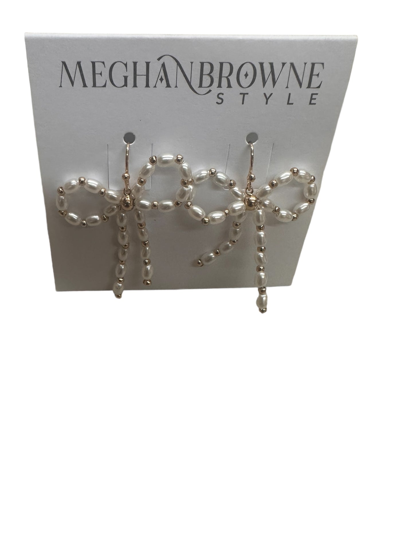 Wren Gold Pearl Bow Earrings: Bow-shaped gold earrings featuring white pearls. Available sizes: One Size. Displayed on a branded "MEGHANBROWNE STYLE" card. Elegant and versatile addition to any jewelry collection.